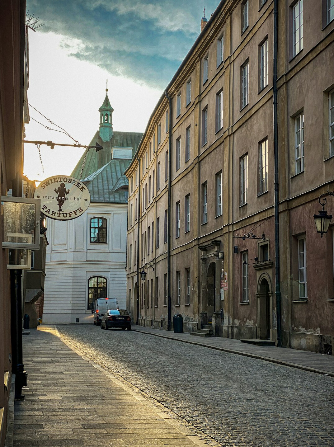 Atmospheric old town street in Poland at dusk with historic townhouses